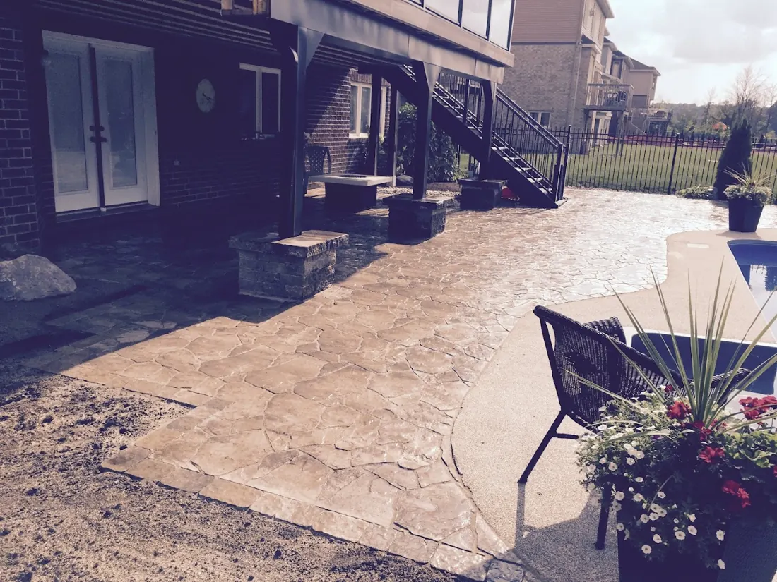 Stamped-concrete style patio with a bistro table and flower pot