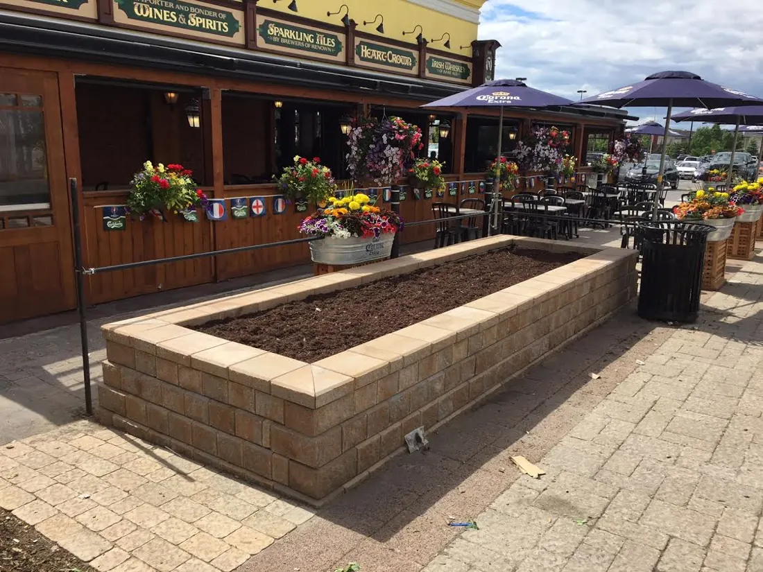 Interlock planter bed beside a restaurant patio with umbrellas